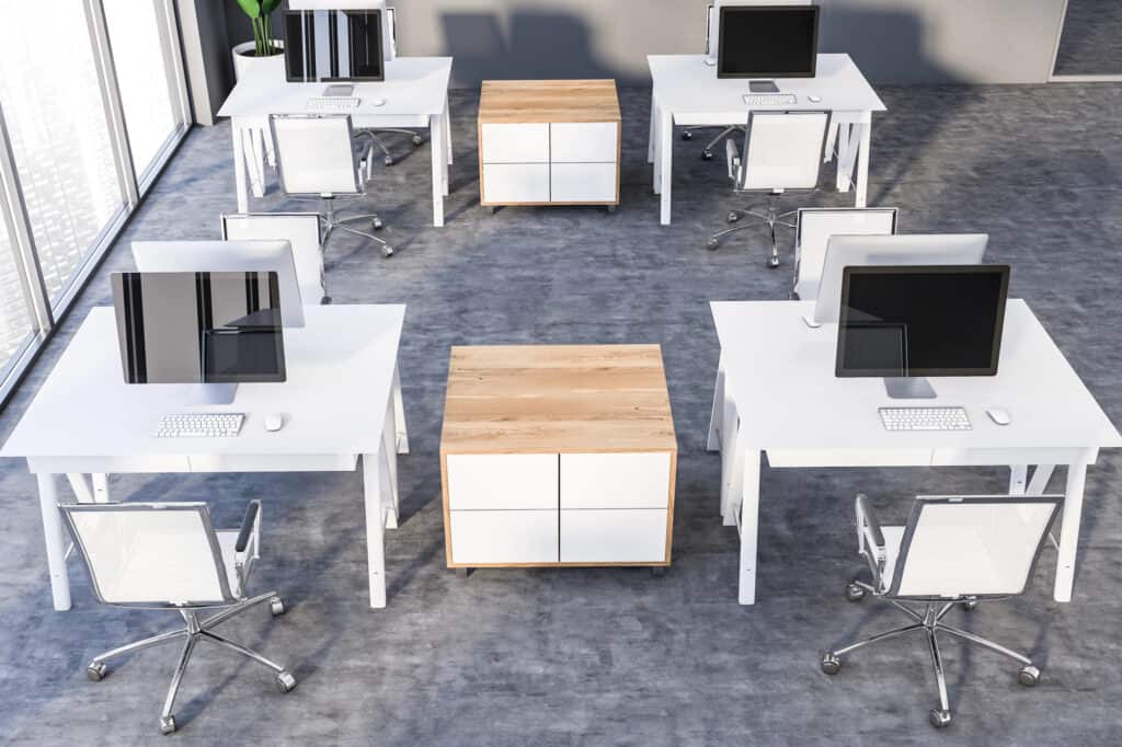 An empty new office with desks, drawers and computers.