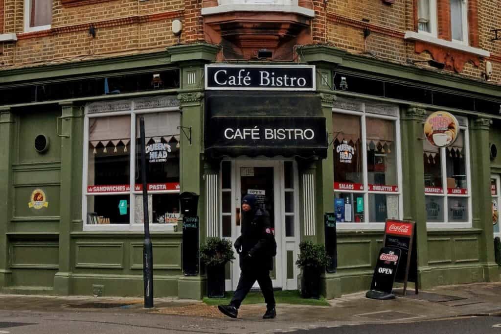 A man is walking outside a Cafe Bistro