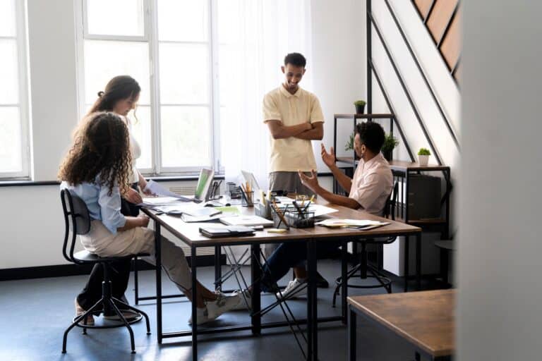 A group of young professionals working in the office in the concept of 'How to Minimise Disruption During an Office Move to Dulwich'.